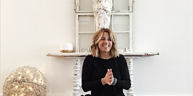 Kelly Mitchell smiling with hands in prayer