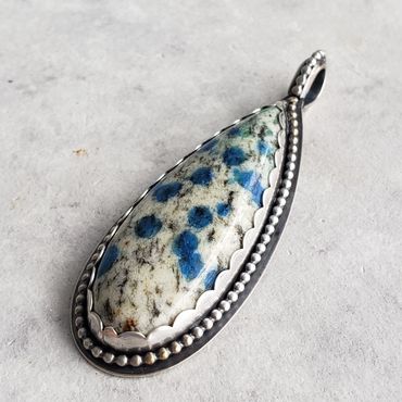 Rare K2 Jasper with azure blue, set in fine and sterling silver. Beaded frame and pierced back.