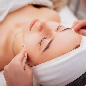 A girl taking massage on a girl face at a massage parlor