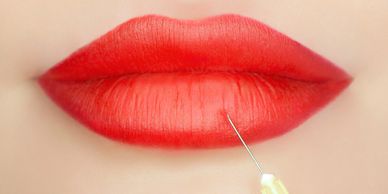 Close up image of a lady touching syringe on the red color lips