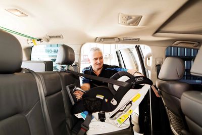 Man installing a car seat in a vehicle.