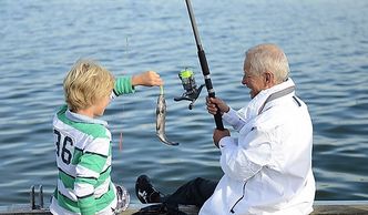 older man fishing with young child