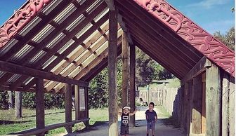 two small children standing in the entrance of a marae