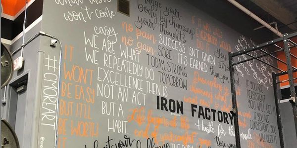 inspirational wall of quotes inside gym for personal training and getting a good workout