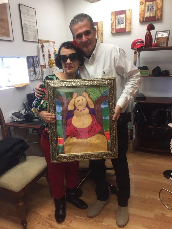 Foto de paciente haciendo un regalo de una pintura para Miami Acupuntura