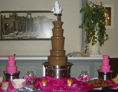 Large chocolate fountain, with 2 small white chocolate fountains colored pink on each sides.