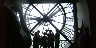 People behind a larger than life clock.