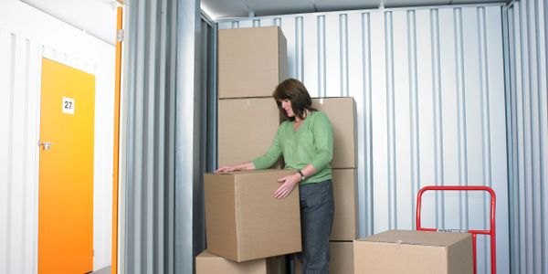 Woman in a container room carrying objects for a business