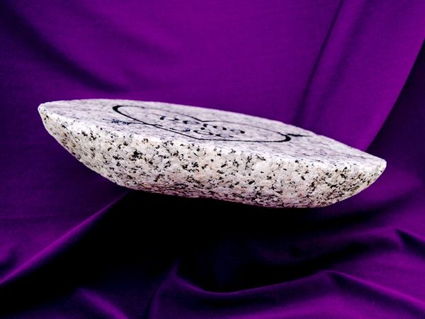 Side view of an engraved split river rock.