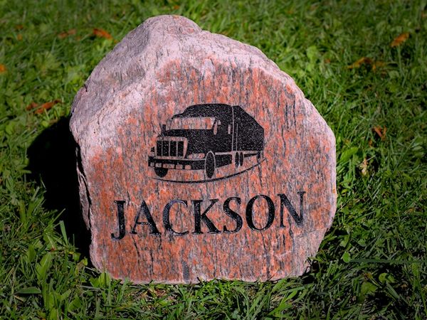 Engraved river rock with Jackson trucking logo.