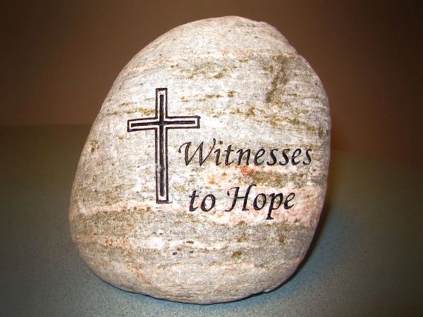 River rock engraved with witnesses to hope message