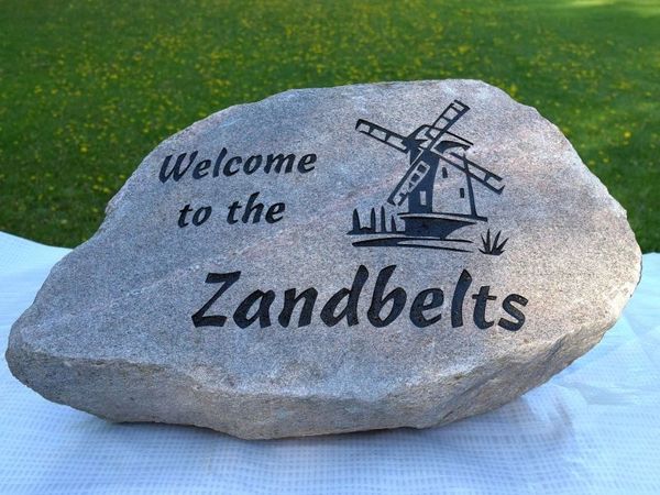 Large engraved stone with polished face showing windmill logo and Zandbelt name