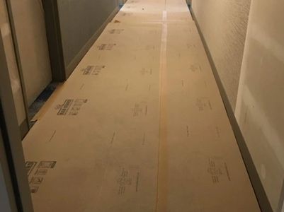 Hallway with covered floor has been swept and cleaned in preparation for next stage of construction.