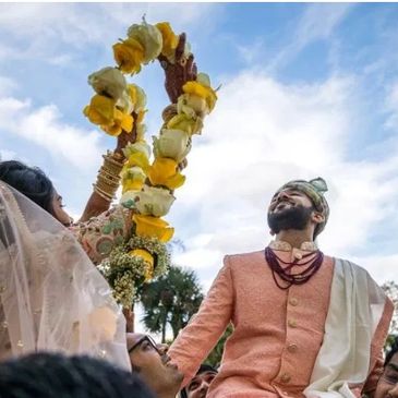 Indian bride is trying to put the varmala ( Garland) on the Groom after the Baarat welcome