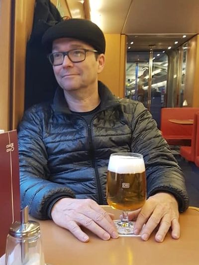 barry sitting on a train with a beer