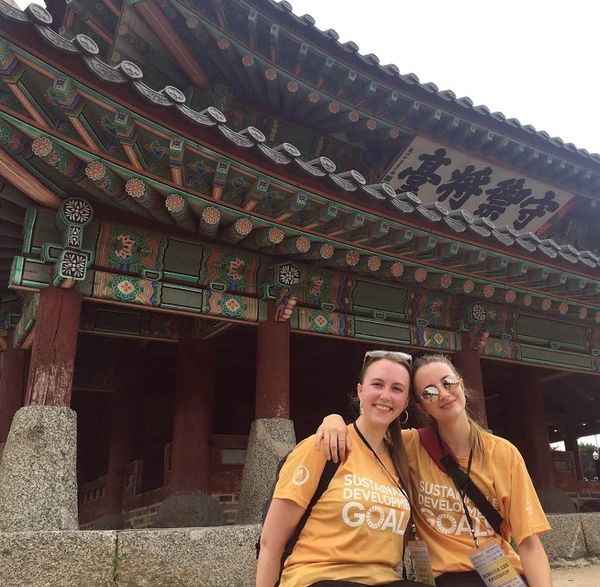 women in front of traditional palace in Seoul
