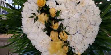 24" solid heart shape funeral heart, white carnation divided with yellow roses.