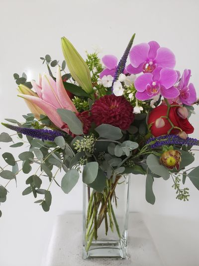 flowers arrangement, Red roses, eucalyptus, orchids and pink lilies in a clear square glass vase. Oceana Florist, Surrey, can help brighten up and enhance the mood at your workplace with customized bouquet to perfectly compliment your corporate office, restaurant, and hotel space.
Oceana Florist offers flower delivery of unique Fresh Flowers arrangements Daily to Offices, Medical Clinics, Hotels and Banks. We specialize in Corporate account flowers