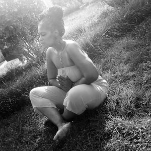 A woman meditating on grass