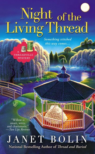 An elaborate wedding skirt in a gazebo in a park in Threadville on a moonlit night on the cover of Night of the Living Thread by Janet Bolin