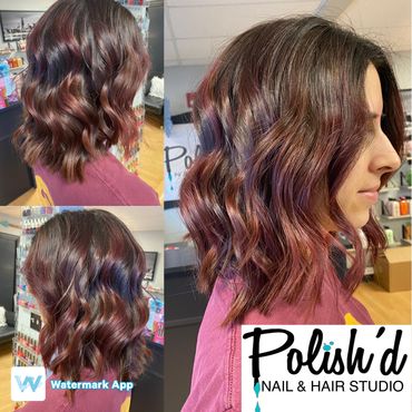 Wavy shoulder-length hair with purple highlights.