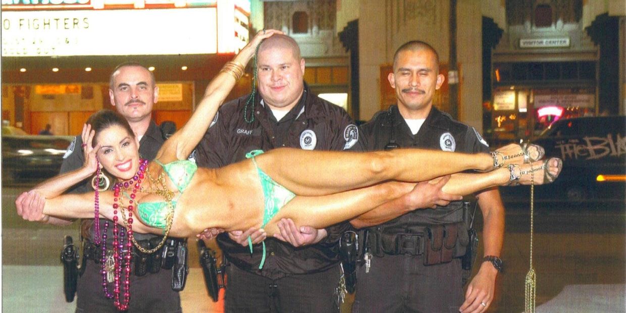 The model Deprise held up by three security officers in bathing suit on Hollywood Blvd