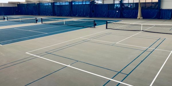 indoor tennis courts with blue and grey surface at richmond hill country club