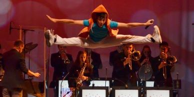 Photo of Alex doing a split jump during the Kids From Wisconsin summer tour