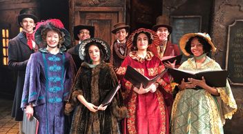 Photo of cast members singing Christmas carols for the show A Christmas Carol at Milwaukee Rep