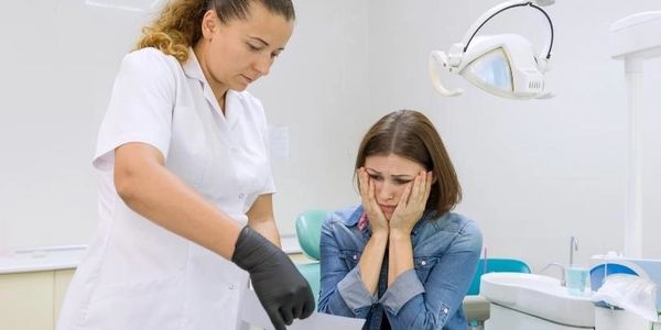 A girl along with a nurse taking a dental checkup.