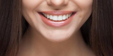 An image of a girl smiling showing her teeth.