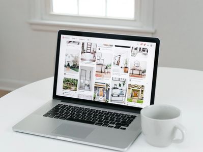 Laptop displaying pins with a white coffee cup nearby.