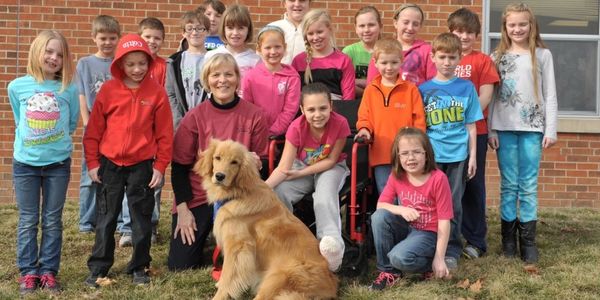 group of kids holding dog