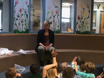 Nancy Carlisle, reading to a group of elementary school students, environmental enthusiasts and youn