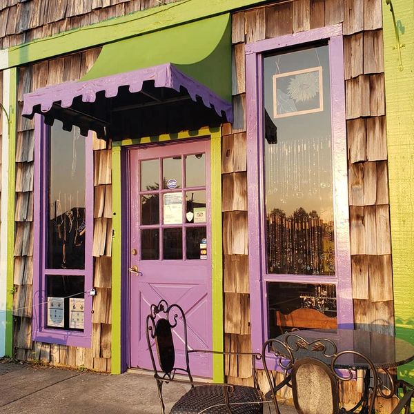 Charming storefront with purple door and green trim.