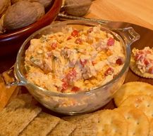 Pimento cheese served with crackers and whole nuts.