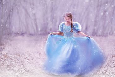 blonde girl in blue gown in the snow
