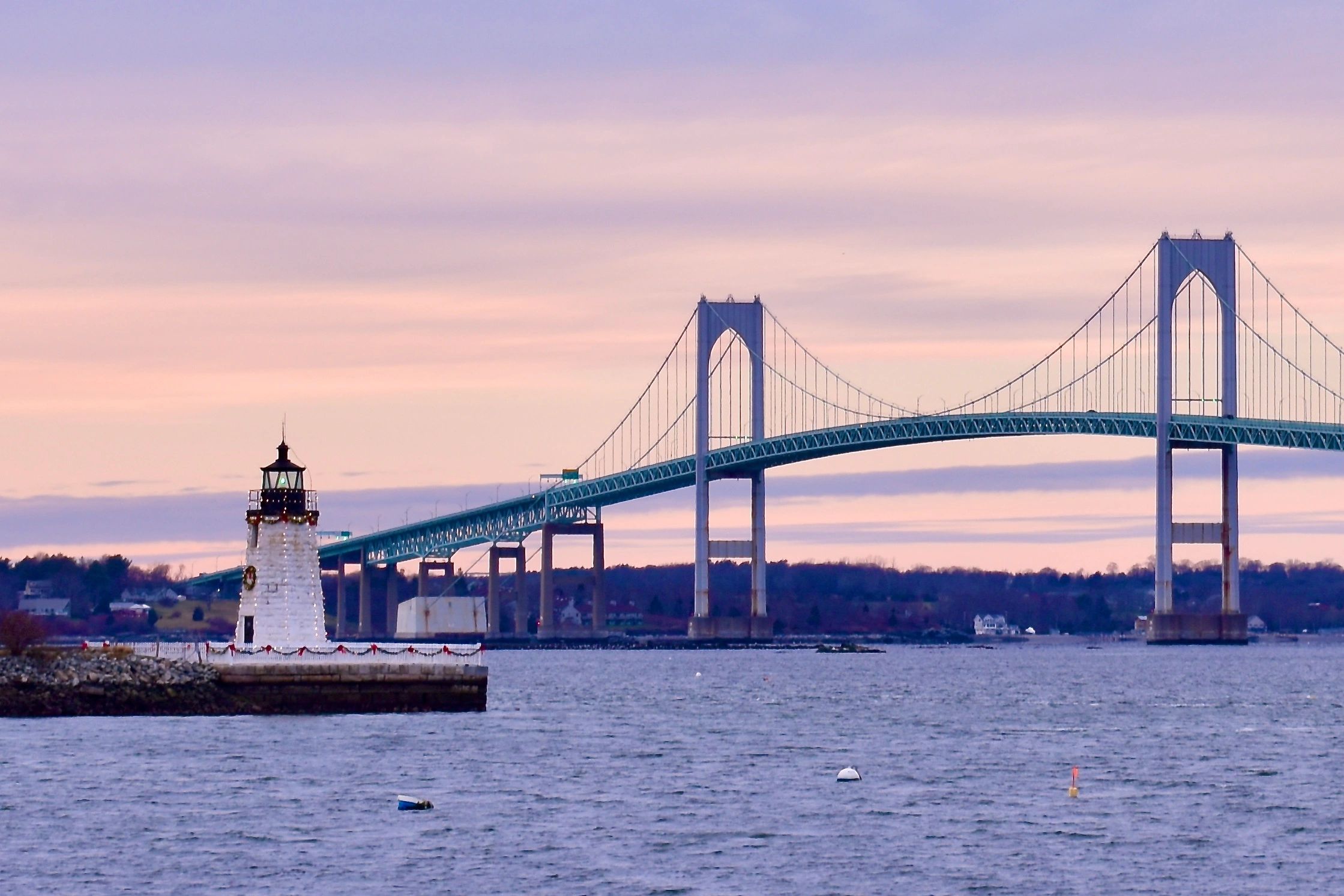 Newport Bridge at sunset and harbor lighthouse with Christmas lights