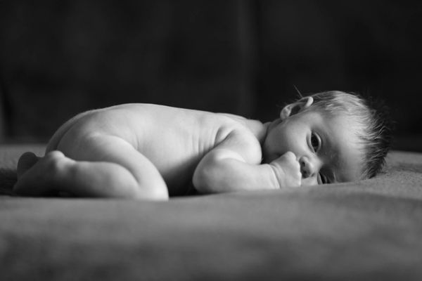 Black and white photo of sleepy, naked baby