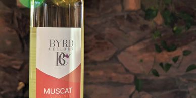 bottle of Byrd Cellars Muscat wine, stone wall background