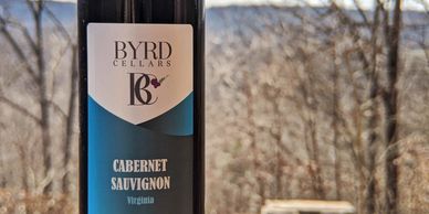 bottle of Byrd Cellars Cabernet Sauvignon Granite Stone bench and Forest in background