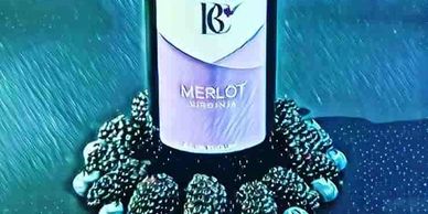 bottle of Byrd Cellars Merlot with blueberries and blackberries around bottom