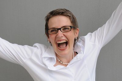 Happy woman celebrating with outstretched arms and big smile