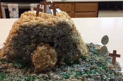 Calvary Hill presented as a chocolate cake with tan coconut as dirt & green coconut as grass. 