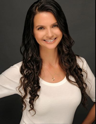 A smiling woman with wavy hair