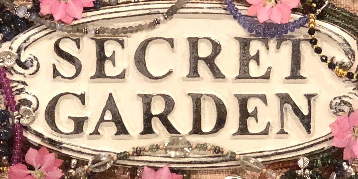 Secret Garden Studio sign adorned with gemstone jewelry