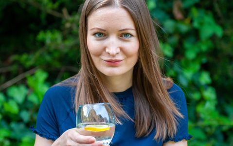 A woman with a glass of lemon water