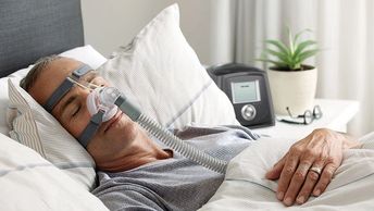male patient sleeping while wearing CPAP mask