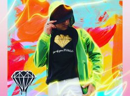 Playera ZUAGGI de diamante dorado en un fondo colorido debajo de una chamarra