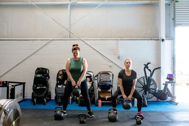 Mums lifting kettlebells in the gym